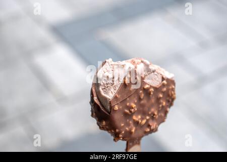 Schokoladeneis mit Haselnuss und klassischer Milchschokolade. Machen Sie Fotos mit einem verschwommenen öffentlichen Ort als Hintergrund Stockfoto