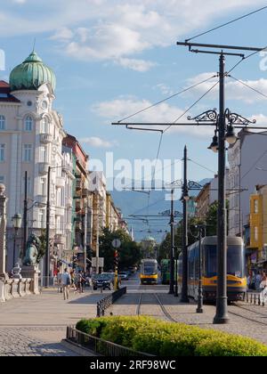 Straßenbahn auf der Löwenbrücke mit Boulevard Knyaginya Maria-Luiza, Banya Bashi Moschee und Hügeln dahinter. Sofia, Bulgarien. August 2023. Stockfoto