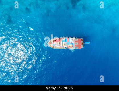 Luftaufnahme eines einsamen Bootes mit entspannenden Menschen auf dem Meer Stockfoto