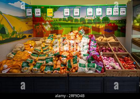 Italien - 29. Juli 2023: Kartoffeln und Zwiebeln verschiedener Art in Verpackungen, ausgestellt auf einem Verkaufsstand in einem italienischen Supermarkt Stockfoto
