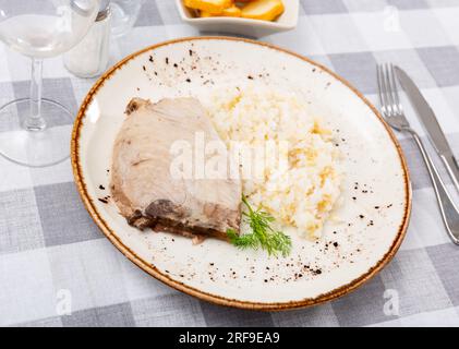 Gegrillte Thunfisch-Steaks mit weißem Reis, serviert auf einem Teller mit Besteck und Brot Stockfoto