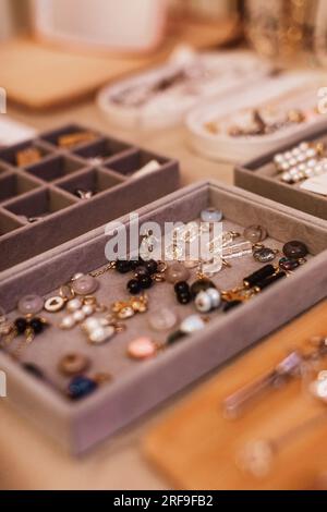 Ohrringe mit Steinen, Schmuck auf dem Schaukasten von Damenaccessoires. Vertikales Modefoto Stockfoto