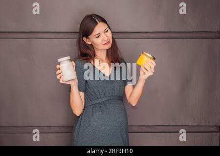 Eine glühende schwangere Frau über 40 Jahre, die Ghee und Kokosnussöl für eine gesunde und lebendige Schwangerschaftsreise genießt Stockfoto