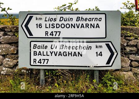 Traditionelles irisches Straßenschild nach Lisdoonvarna und Ballyvaghan in englischer und gälischer Sprache Stockfoto