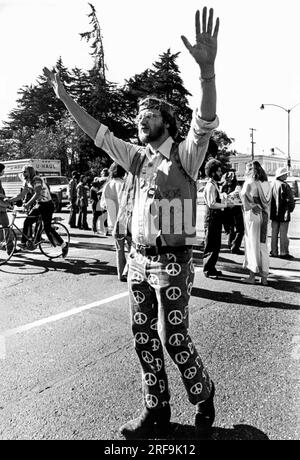 San Francisco, Kalifornien: ca. 1968 Ein großer Hippie trägt Friedenssymbole auf seiner Hose bei einer Demonstration, die gegen den Krieg in Vietnam protestiert. Stockfoto