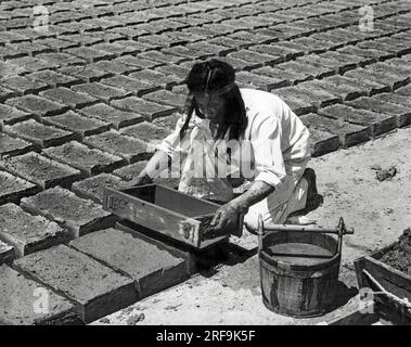 Kalifornien: ca. 1930 die padres lehrten die Indianer, die ziegel zu bauen, die für die Missionen verwendet wurden. Die Form wurde durch vorsichtiges Wackeln gelockert und dann aus dem geformten Ziegel gezogen. Nach jedem dritten Ziegel wurde die Form gründlich gewaschen, um den klebrigen adobe zu entfernen. Stockfoto