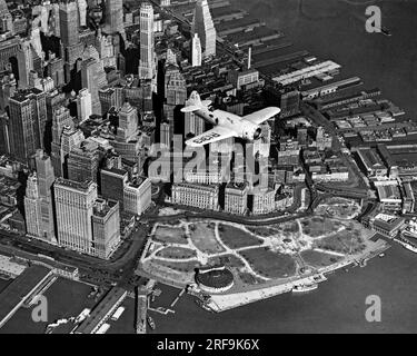 New York, New York: 3. April 1937 eine Luftaufnahme von Captain Frank Hawks' neuem Schnellflugzeug, als er es heute über New Yorks Battery Park und Financial District flog. Er erwartet, damit viele neue Geschwindigkeitsrekorde zu setzen. Stockfoto