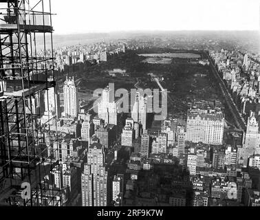 New York, New York: 1933 umgeben von luxuriösen Hotels und den Gebäuden eines belebten Manhattan, wird der Central Park von Süden aus vom Gerüst des im Bau befindlichen RCA-Gebäudes im Rockefeller Center, dem größten Gebäude der Welt, gesehen. Auf dem Gipfel des Parks befindet sich das Reservoir. Stockfoto