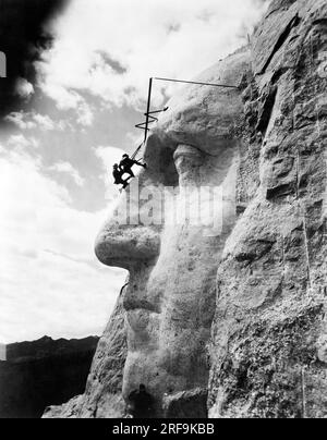 Mount Rushmore, South Dakota: 31. Mai 1932, Bildhauer Gutzon Borglum und seine Inspektionsarbeit an der Nase von George Washington. Stockfoto