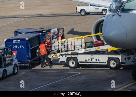 Männer, die an der Gepäckausgabe für ein Flugzeug arbeiten, werden am Dallas-Fort Worth International Airport (DFW) in Dallas Texas in den USA am Stockfoto
