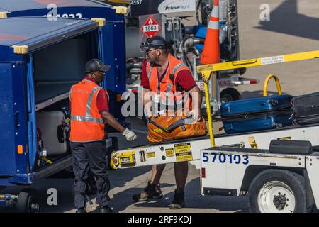 Männer, die an der Gepäckausgabe für ein Flugzeug arbeiten, werden am Dallas-Fort Worth International Airport (DFW) in Dallas Texas in den USA am Stockfoto