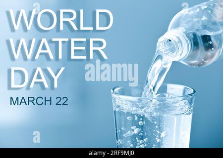 Text World Water Day, 22. März und Gießen von Wasser aus der Flasche in Glas auf hellblauem Hintergrund Stockfoto