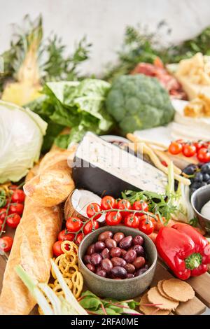 Oliven im Vordergrund. Tisch voller mediterraner Vorspeisen, Tapas oder Antipasto. Auswahl an italienischen Speisen. Köstlicher Snack auf einer Party oder Picknick Stockfoto