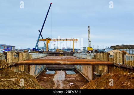 Ein riesiger Gräben-Tunnel mit Verstärkungsstrukturen aus dicken Eisenrohren und Bauten auf der Baustelle des unterirdischen Me Stockfoto