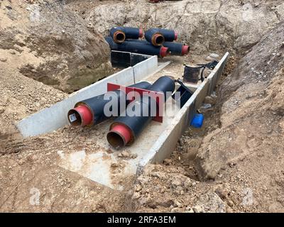 Große industrielle moderne neue Polyethylen-Kunststoff-Wasserrohre mit großem Durchmesser liegen während der Reparatur von Wasserrohren in einer Grube unter der Erde auf einer Baustelle Stockfoto