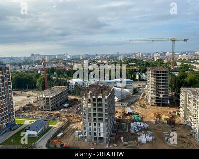 Ein Blick aus der Höhe einer großen modernen Baustelle mit hohen, großen Häusern und mehrstöckigen Gebäuden. Eine Baustelle für die Entwicklung eines Stockfoto