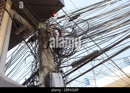 Unordentliche elektrische Kabel in Nepal Beispiel für die ungedeckte Glasfasertechnologie, Lichtmast mit verwickelten Drähten, Leitung am elektrischen Pol auf der Straße Stockfoto