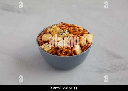 Hausgemachter Party-Snack-Mix mit Crackern und Brezeln in einer Schüssel, Seitenblick. Stockfoto