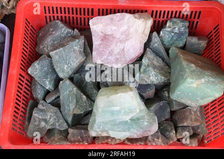 Naturgestein und Steine in verschiedenen Farben in einem Korb in der Straße von Nepal zum Verkauf Stockfoto