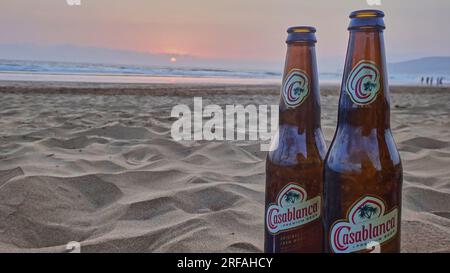 Casablanca, Marokko - 05 19 2016 Uhr: Bierflasche Casablanca Braut an einem Sandstrand vor einem romantischen Sonnenuntergang am atlantischen Ozean. Stockfoto