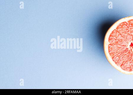 Nahaufnahme der Hälfte der roten Grapefruit und Kopierbereich auf blauem Hintergrund Stockfoto