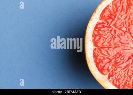 Nahaufnahme der Hälfte der roten Grapefruit und Kopierbereich auf blauem Hintergrund Stockfoto