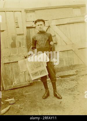 Originale Titanic-Postkarte eines Zeitungsverkäufers im Teenageralter, trägt einen "Ich verkaufe den Daily Express"-Pullover, aber mit der Daily Mirror-Lizenz Nr. 98. Möglicherweise Liverpool, etwa 1912, Großbritannien Stockfoto