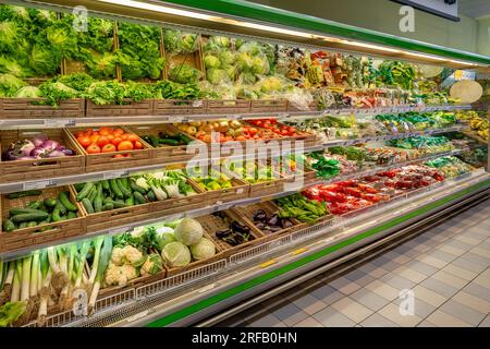 Italien - 01. August 2023: Frisches Gemüse in Kisten und verzehrfertigen Verpackungen auf den Regalen der Kühltheke zum Verkauf in einer italienischen Filiale Stockfoto