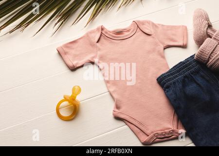 Flache, pinkfarbene Babyschuhe, Shorts, Puppe und pinkfarbene Stiefel mit Kopierfeld auf weißem Hintergrund Stockfoto