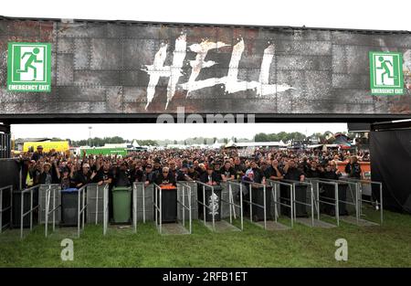 Wacken, Deutschland. 02. Aug. 2023. An einem der Eingänge warten Fans aus Metall auf die Eröffnung des Festivalgeländes. Das Wacken Open-Air (WOA) vom 2. Bis 5. August gilt als das größte Heavy-Metal-Festival der Welt und ist mit 85.000 Besuchern ausverkauft. Kredit: Christian Charisius/dpa/Alamy Live News Stockfoto