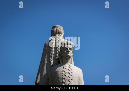 Leiter des Monuments der Befreiung von Dobele, Lettland, mit dem Mann mit einem berühmten lettischen Volkskleid als Hauptbestandteil der Komposition Stockfoto