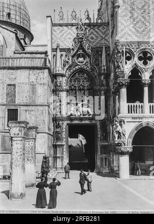 Venedig - ca. 1870 Besucher laufen in der Nähe der Porta della Carta, zwischen dem Dogenpalast und der Basilika San Marco. Die Tür war der monumentale Eingang zum Dogenpalast und wurde zwischen 1438 und 1442 von Bartolomeo Bon für Doge Francesco Foscari erbaut. Bildteil der Serie „Views“ des Naya-Bohm Archivs, V5. Venedig - ca. 1870 Uhr Visitatori passeggiano nei pressi della 'Porta della Carta', Fra il Palazzo Ducale e la Basilica di San Marco. La porta costituiva l’ingresso monumentale di Palazzo Ducale e fu realizzata Fra il 1438 e il 1442 da Bartolomeo Bon per il doge Francesco Foscari Stockfoto