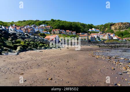 Von dem über Felsen verstreuten Strand Runswick Bay bis zum hügeligen Dorf an einem wolkenlosen Frühlingstag. Stockfoto