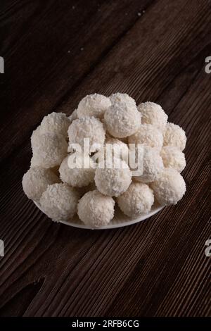 Foto von köstlichen Süßigkeiten mit Kokosnussgeschmack, die auf einem weißen Teller liegen, Aussicht, süßes Essen, Dessert Stockfoto