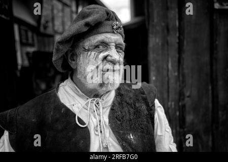Porträt Schwarz-weiß-Fotografie eines älteren Mannes in traditioneller Tudor-Tracht in Tudor World, Stratford upon Avon, England, Großbritannien. Stockfoto