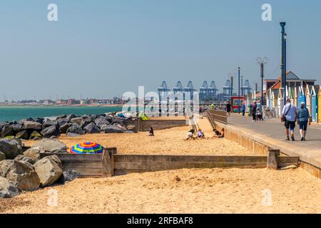 UK, England, Suffolk, Felixstowe, Beach mit Backbordkränen im Hintergrund Stockfoto