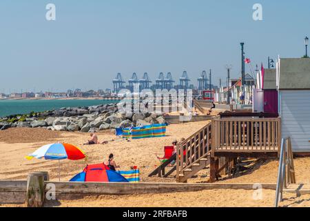 UK, England, Suffolk, Felixstowe, Beach mit Backbordkränen im Hintergrund Stockfoto