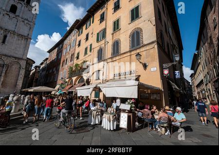 Beliebt bei Touristen mit seiner Mischung an Restaurants auf der Piazza Antelminelli in der Stadt Lucca in der Toskana in Italien. Stockfoto