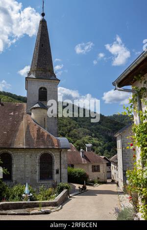 Das malerische Dorf Lods und die Kirche St. Theodule im Departement Doubs in Bourgogne-Franche-Comté in Frankreich. Bereich oben rechts kopieren. Stockfoto