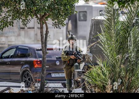 Jordantal, Palästina. 02. Aug. 2023. Ein israelischer Soldat steht Wache neben der Militärpatrouille während der Belagerung des Gebiets in der Nähe des Schussangriffs auf ein Auto jüdischer Siedler, in der Nähe der Siedlung Hamra im nördlichen Westjordanland. Ein zu schnell fahrendes Auto eröffnete das Feuer auf ein Auto, das Siedlern in der Nähe der Al-Hamra-Siedlung gehörte, und verwundete sie. Die israelische Armee umzingelt das Gebiet weiterhin, um den Täter zu verhaften. (Foto von Nasser Ishtayeh/SOPA Images/Sipa USA) Guthaben: SIPA USA/Alamy Live News Stockfoto