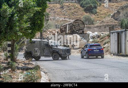 Jordantal, Palästina. 02. Aug. 2023. Israelische Soldaten stehen während der Belagerung des Gebiets in der Nähe des Schussangriffs auf ein Auto jüdischer Siedler in der Nähe der Siedlung Hamra im nördlichen Westjordanland neben ihren militärischen Patrouillen Wache. Ein zu schnell fahrendes Auto eröffnete das Feuer auf ein Auto, das Siedlern in der Nähe der Al-Hamra-Siedlung gehörte, und verwundete sie. Die israelische Armee umzingelt das Gebiet weiterhin, um den Täter zu verhaften. (Foto von Nasser Ishtayeh/SOPA Images/Sipa USA) Guthaben: SIPA USA/Alamy Live News Stockfoto