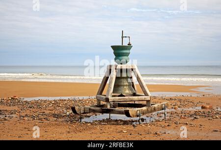 Die „Spirit of Happisburgh Time and Tide Bell“-Installation befindet sich am Strand zwischen Low und High Watermark in Happisburgh, Norfolk, England, Großbritannien. Stockfoto