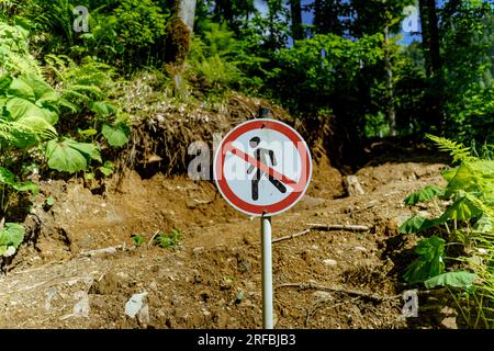 Das Schild „Walking Forbidden“ im Park oder Wald. Verbot des Betretens auf Berghang Stockfoto