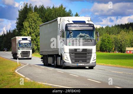 Zwei weiße Volvo FH Sattelanhänger transportieren Güter auf der Autobahn 2 an einem Sommertag. Jokioinen, Finnland. 21. Juli 2023. Stockfoto