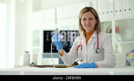 Lächelnder Arzt mit Ultraschallsonde in der Klinik Stockfoto