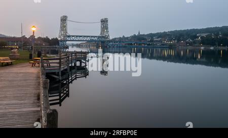Die Morgendämmerung beginnt über der Portage Lake Lift Bridge, vom Porvoo Park im Keweenaw Waterway, Hancock, Michigan. Stockfoto