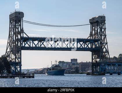 Ranger III Schiff, das durch die Portage Lake Lift Bridge (Aufzug ist oben) fährt, vom Porvoo Park, im Keweenaw Waterway, Hancock, Michigan. Stockfoto