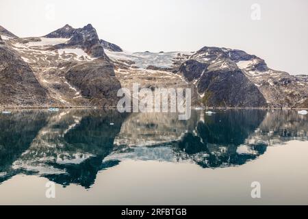 Wunderschöne arktische Landschaft mit felsigen Bergen und Gletschern mit Schnee im stillen Wasser des Prinzen christian Sound grönland Stockfoto