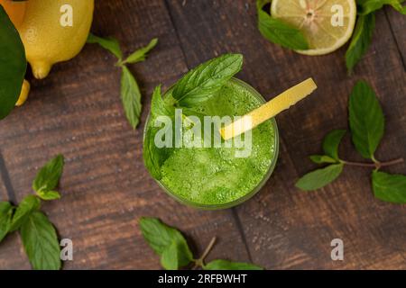Limonade mit Eis und Minze in Glas auf Holztisch Stockfoto