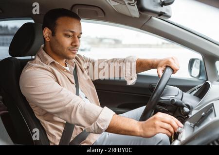 Arabischer Fahrer, Der Auto Fährt, Die Knöpfe Auf Dem Armaturenbrett Drückt Stockfoto